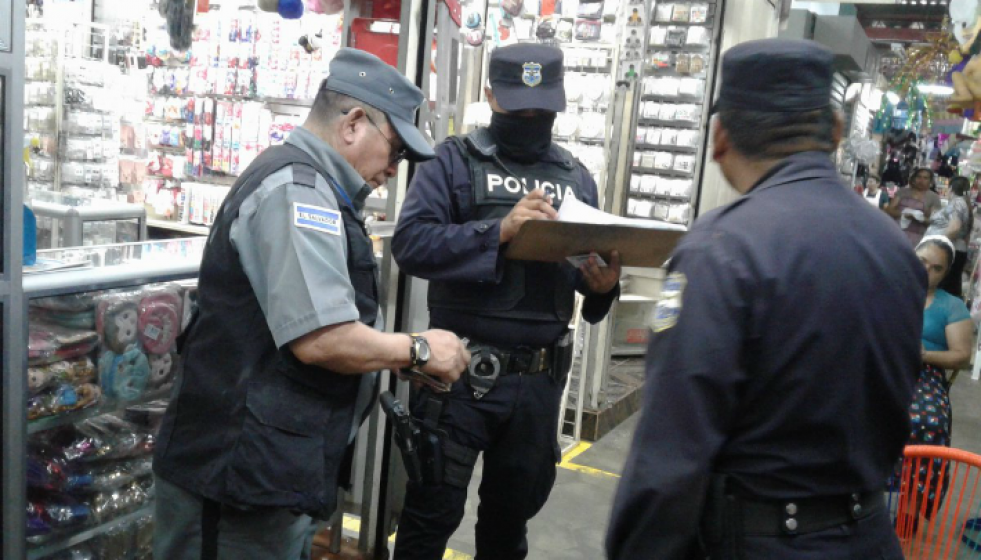 Agentes policiales revisan documentos de autorización a un vigilante privado izquierda. Foto: Policía Nacional