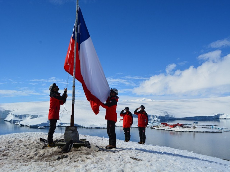 Personal de la base Bernardo O´Higgins iza la bandera chilena en el islote Kopaitic de la Antártica Firma Ejército de Chile