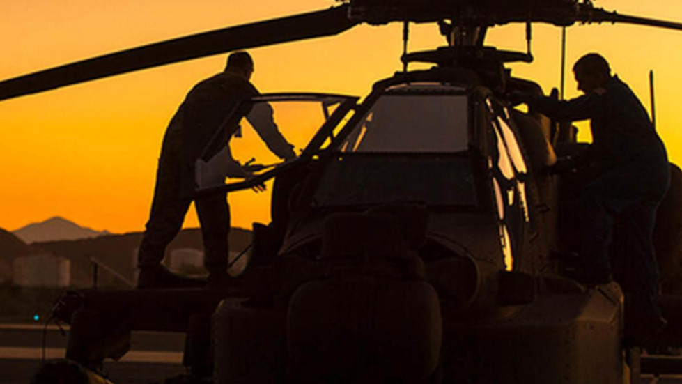 Operarios trabajando en un helicóptero de ataque AH 64 Apache. Foto. Boeing