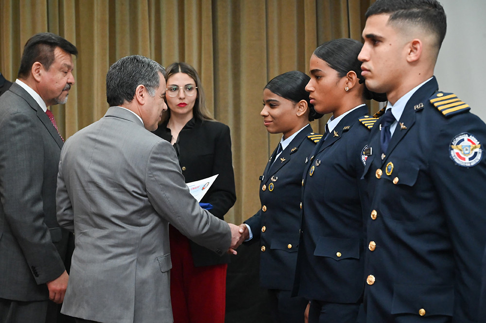 Entrega de diploma a una de las graduadas del programa de Enaer Firma FACh