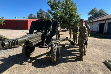 Alumnos junto a un obús Oto Melara M 56 de 105 mm Firma Escuela de Artillería del Ejército de Chile